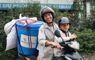 Man and child on motorbike with a can of Samaritan's Purse supplies on the back