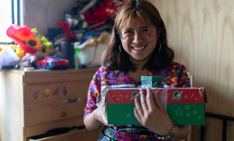 Angelita smiles holding shoebox gift
