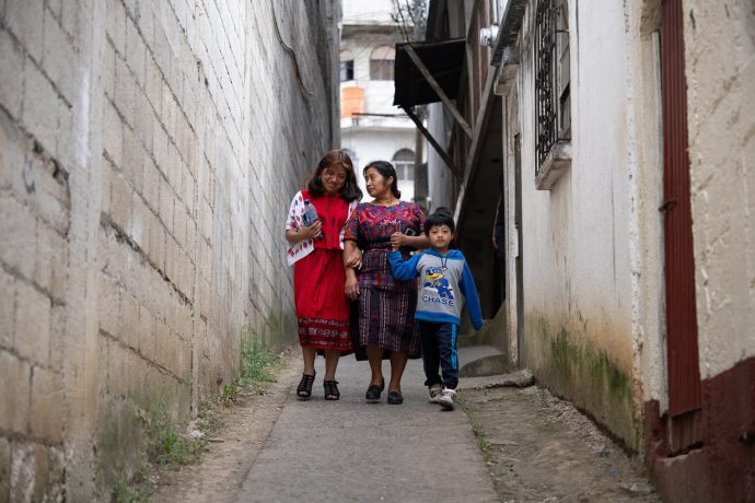 Angelita and her mother and brother walk down an alley near their home.