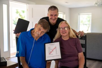 TOMMY, MARY, AND DALLAS POSE WITH THEIR "PAID IN FULL" PLAQUE.